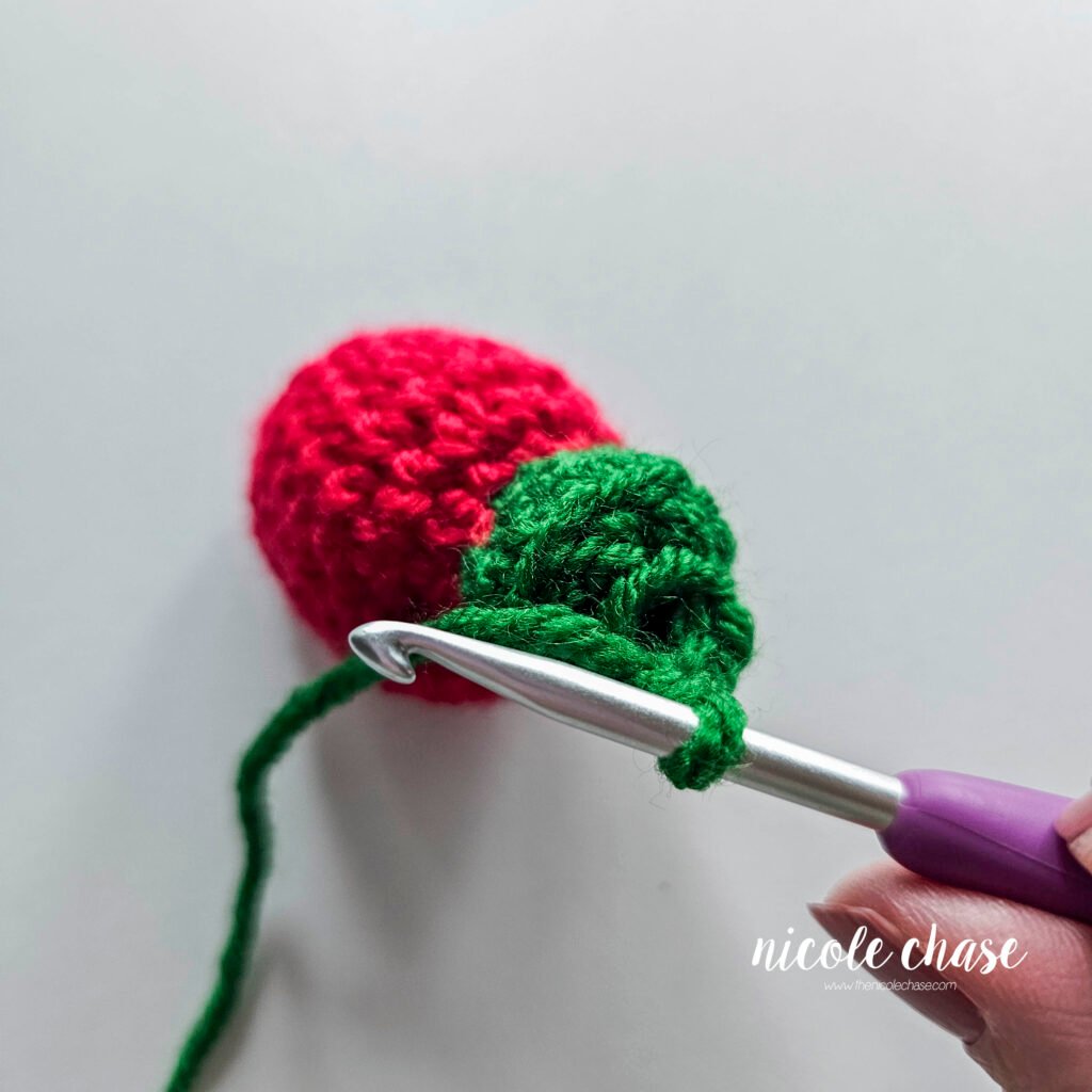 After switching to the green yarn, close-up showing the finished base of the bulb, after the final round. 