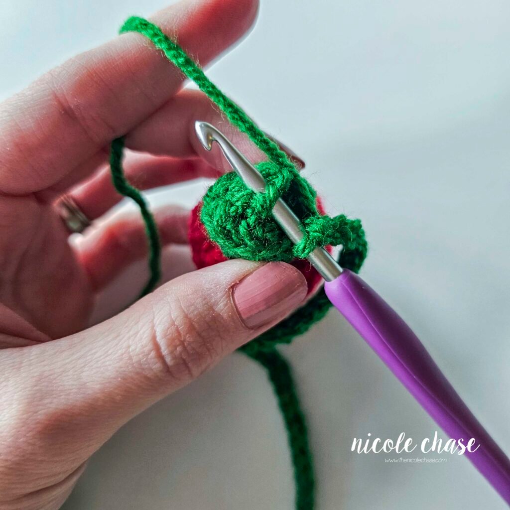 Connecting the green chain to the top of the first crochet holiday light, step 2.