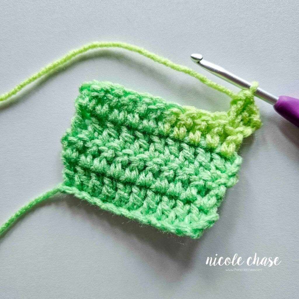 Swatch of dc stitches showing a completed double crochet increase.