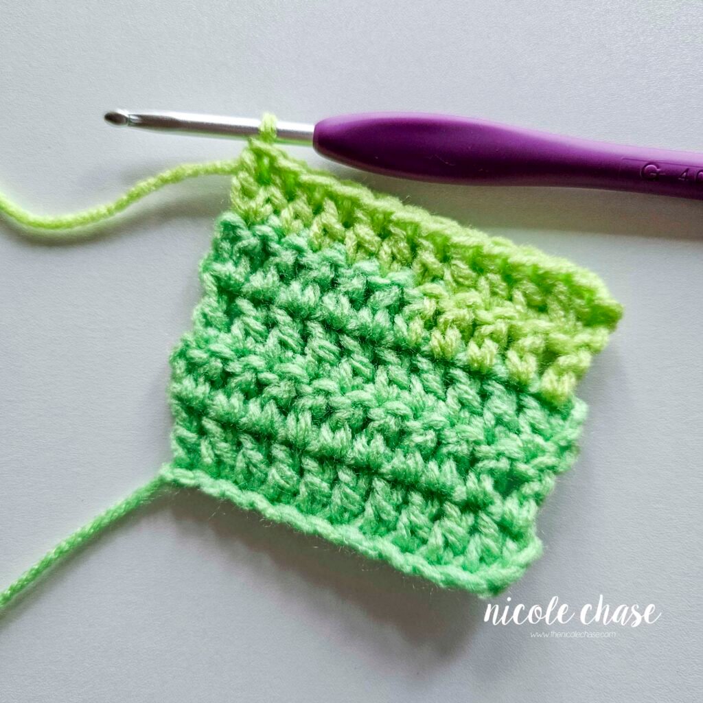 Swatch of double crochet stitches after the increase at the end of the row has been completed.