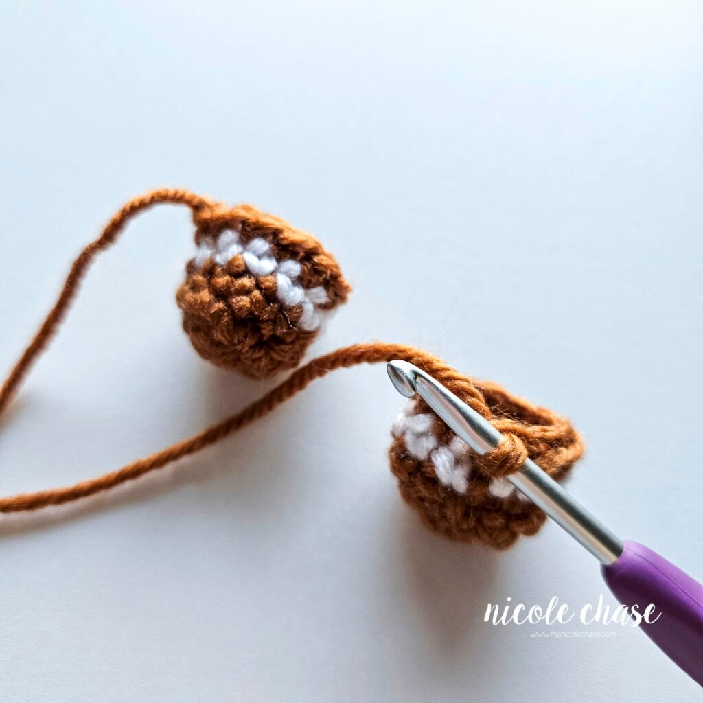 Tutorial photo showing the method for joining the two crocheted legs together at the start of the nearly no-sew crochet gingerbread man pattern, step 1.