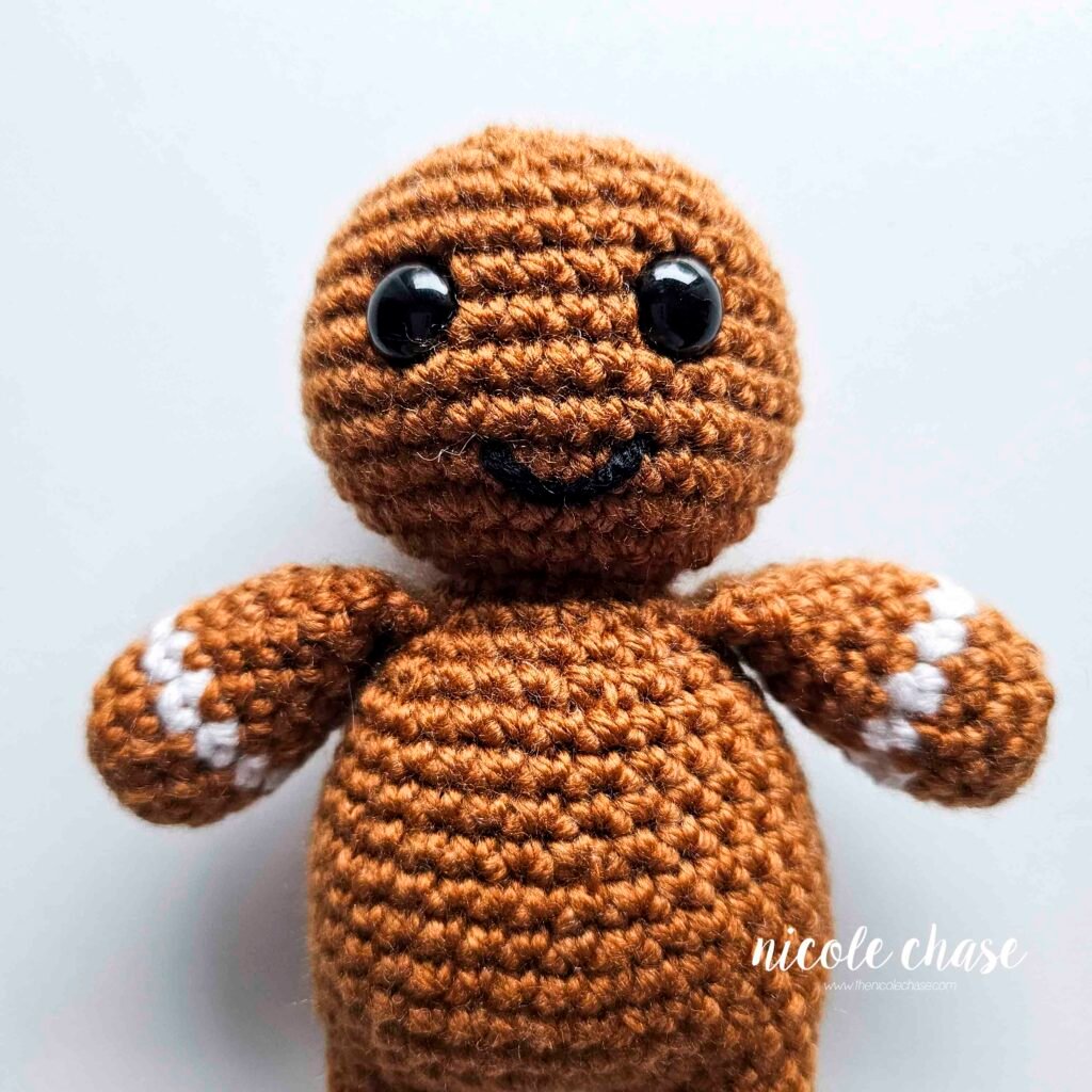 The smile has been embroidered on the face of the free gingerbread man crochet pattern. 
