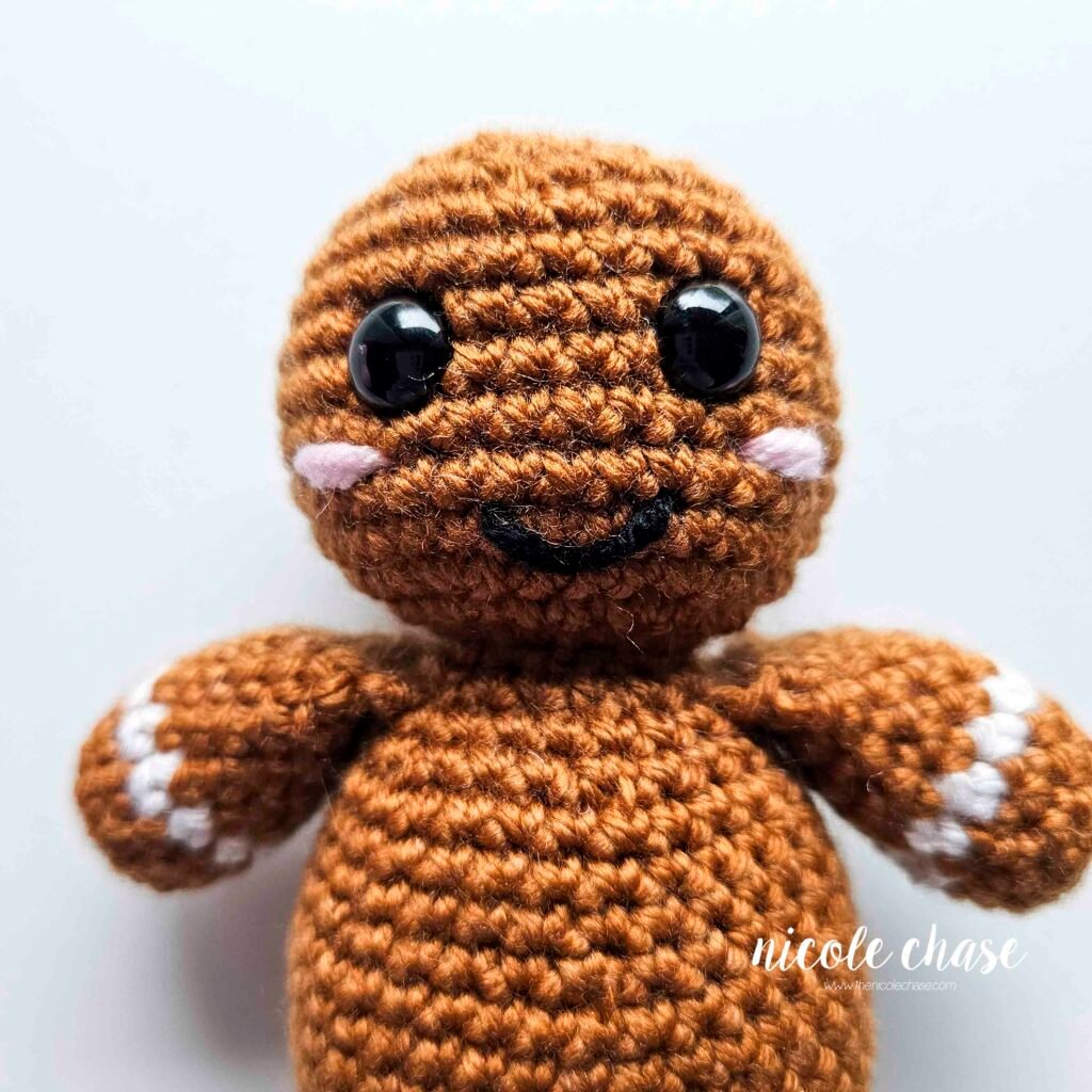 The blush has been embroidered on the face of the free gingerbread man crochet pattern. 