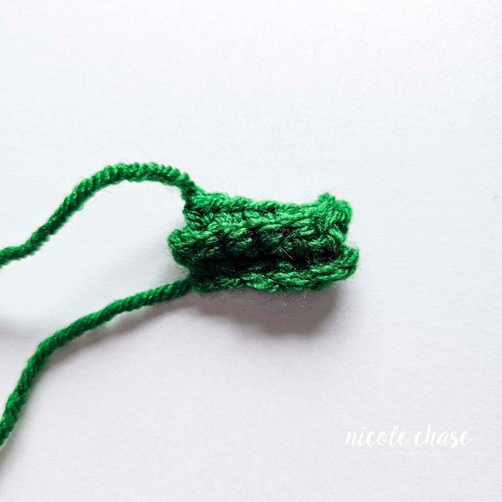 A small rectangle of crocheted stitches, prior to the ends being weaved in and the forming of the bow. 