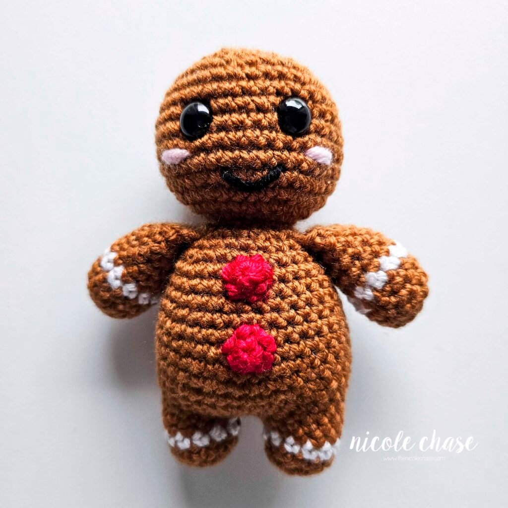 The buttons of the free crochet gingerbread man pattern have been sewn into place on the body. 