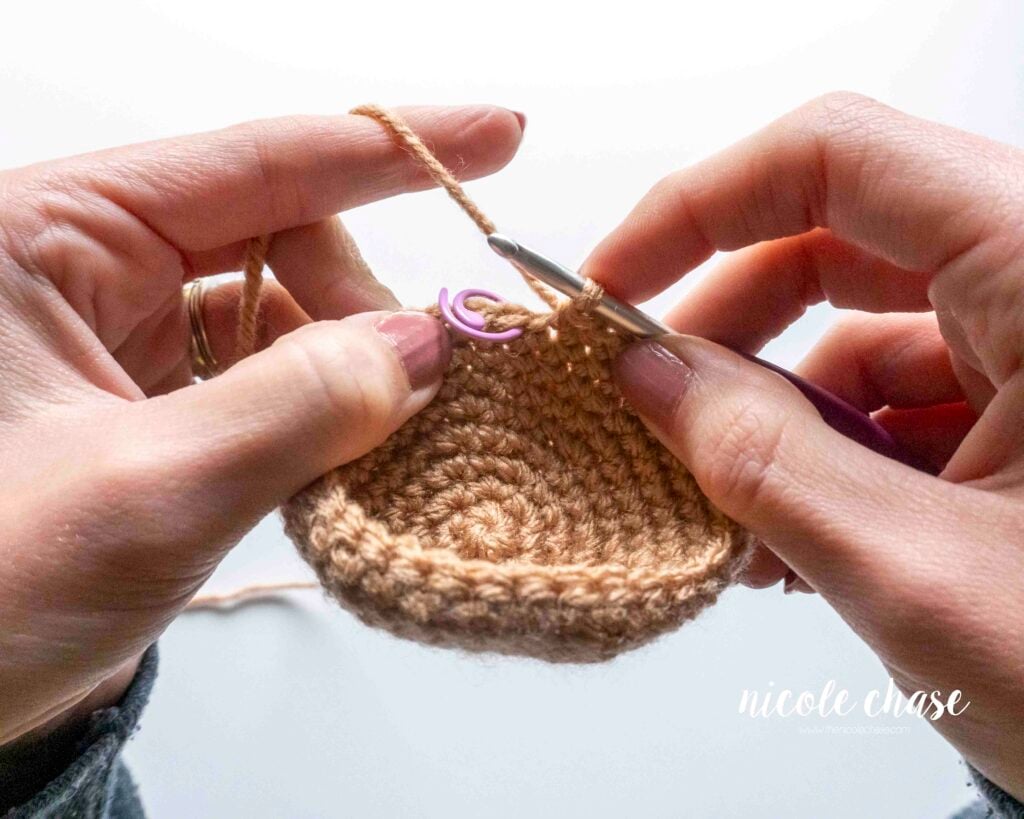 Step-by-step tutorial showing how to flip a larger, more structured amigurumi piece inside out when realizing the wrong side is facing out in later rounds, step 2.