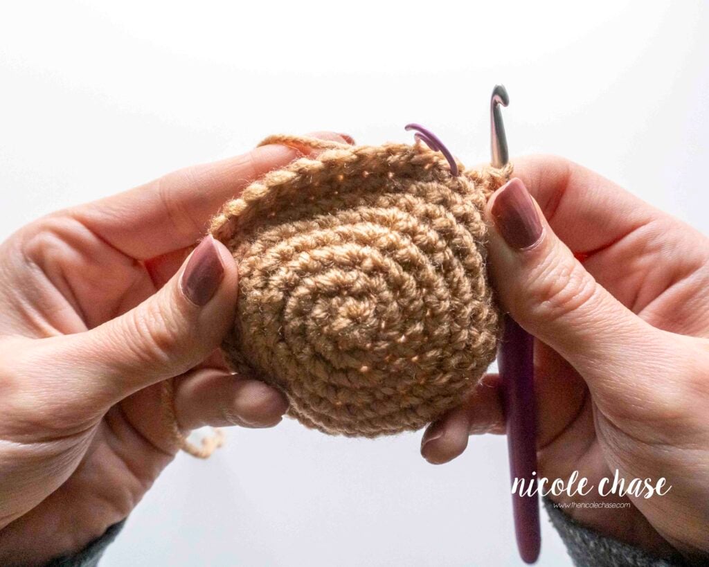 Step-by-step tutorial showing how to flip a larger, more structured amigurumi piece inside out when realizing the wrong side is facing out in later rounds, step 4.