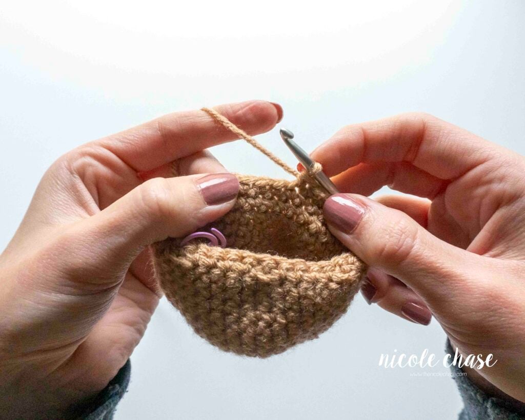 Views of a hand attempting to crochet the decreasing round when the piece is inside-out. The workspace is tight and restrictive.