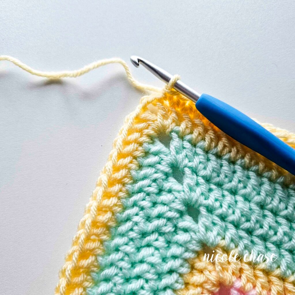 Crocheting the single crochet edging around the blanket of the crochet lion lovey pattern, step 3.