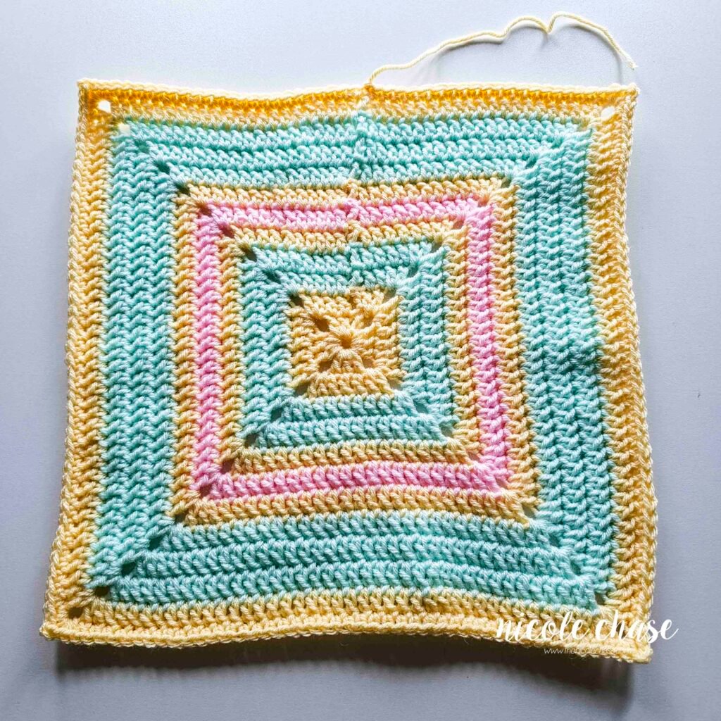 Crocheting the single crochet edging around the blanket of the crochet lion lovey pattern, step 6.