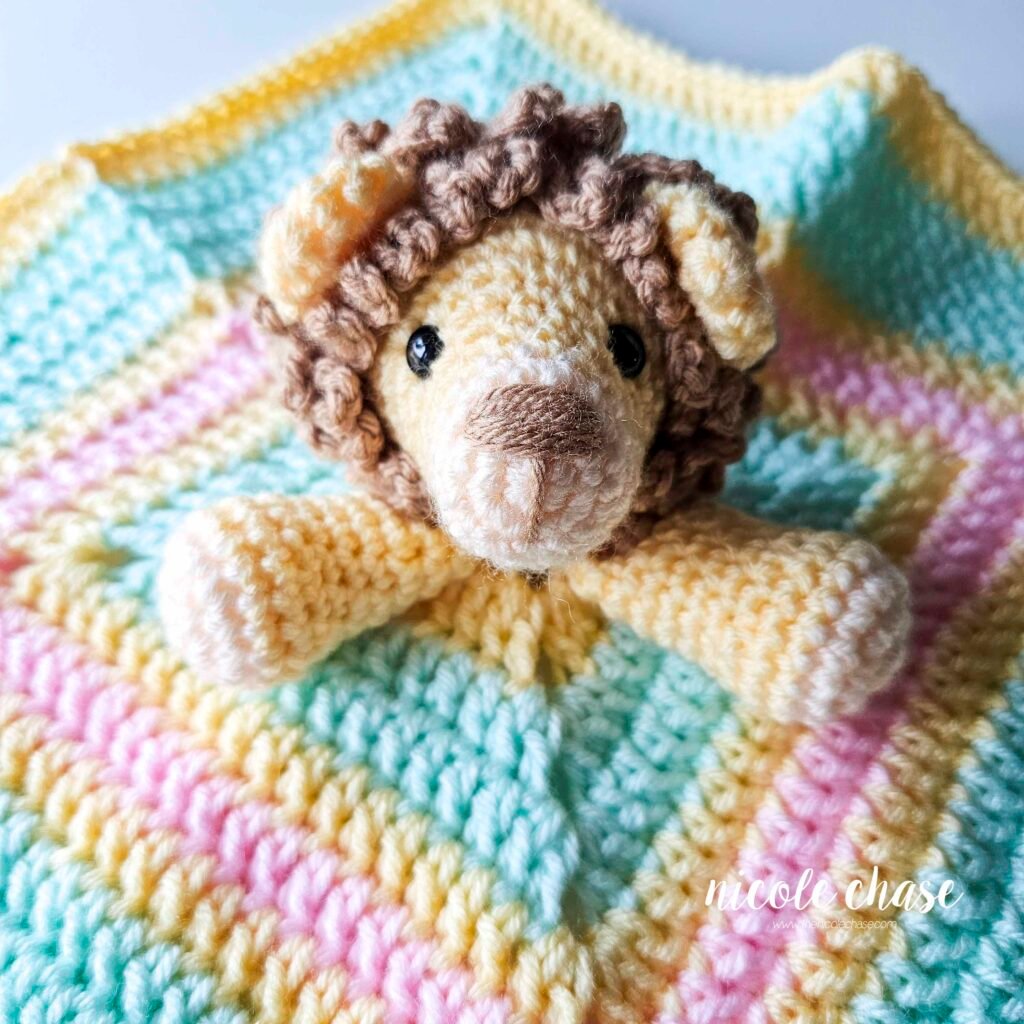 Crochet arm placement for the Hug Me Lion Lovey crochet pattern after being sewn in place, view 2.