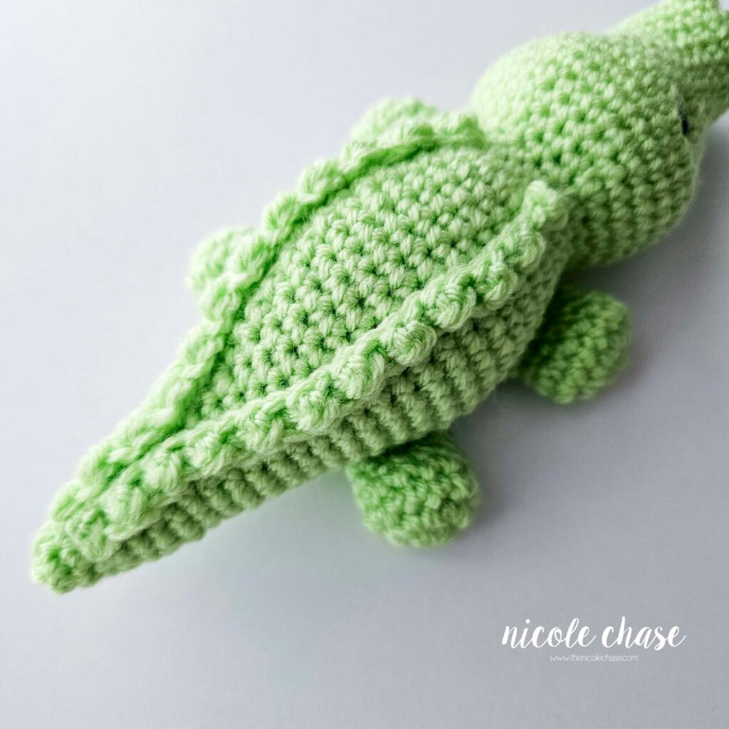 The ridges have been sewn into place on the back of the crochet alligator's body, view 3.