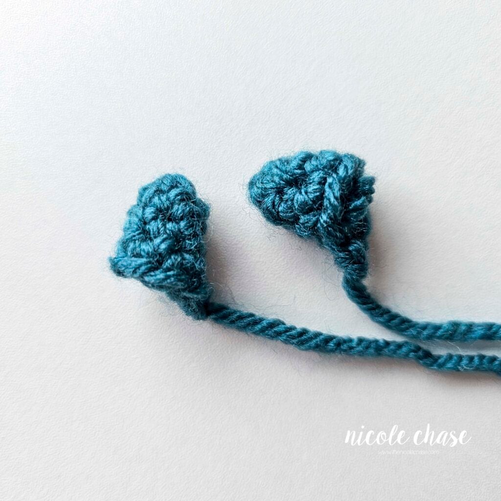 Two small spikes made in teal yarn for the crochet dragon.