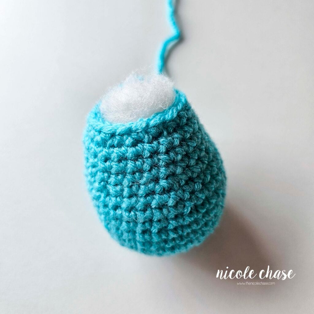 Body of the crochet dragon made in a bright blue yarn and filled with polyfil stuffing.