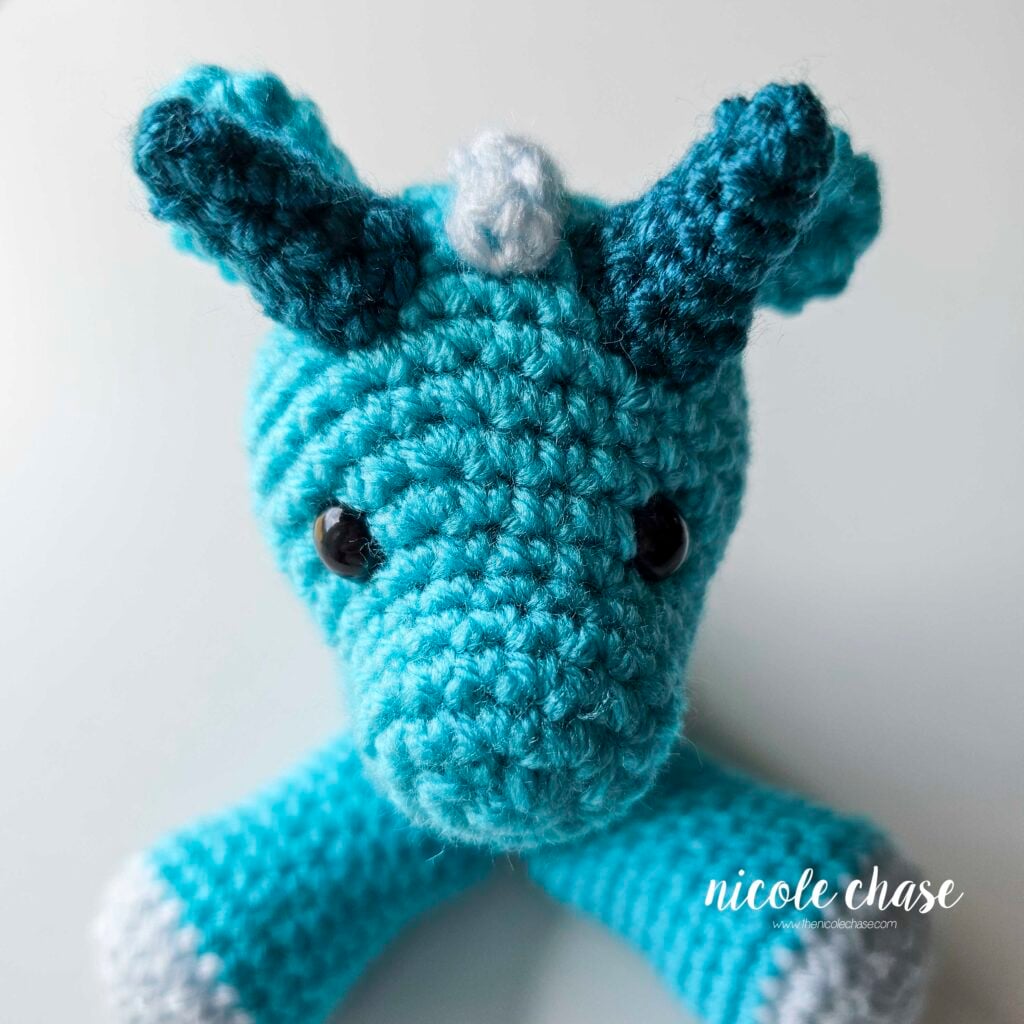 The large spikes have been sewn into place on the top of the head, on either side of the ridges, view from the front of the dragon's face.