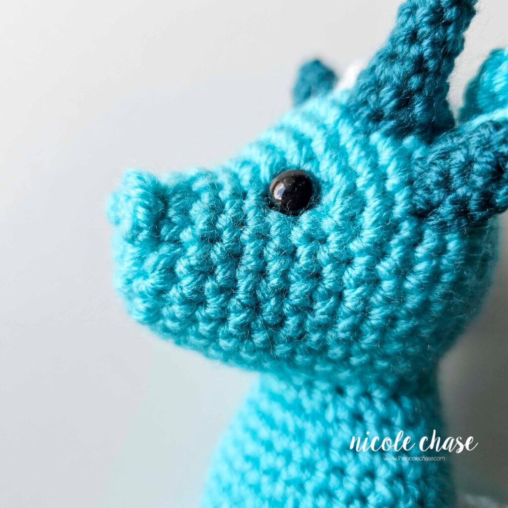 Side view of the amigurumi dragon's nostrils, showing their bumpy texture.