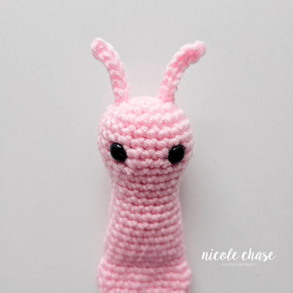 The two crochet snail antennas have been sewn into place on top of the head, view 2.