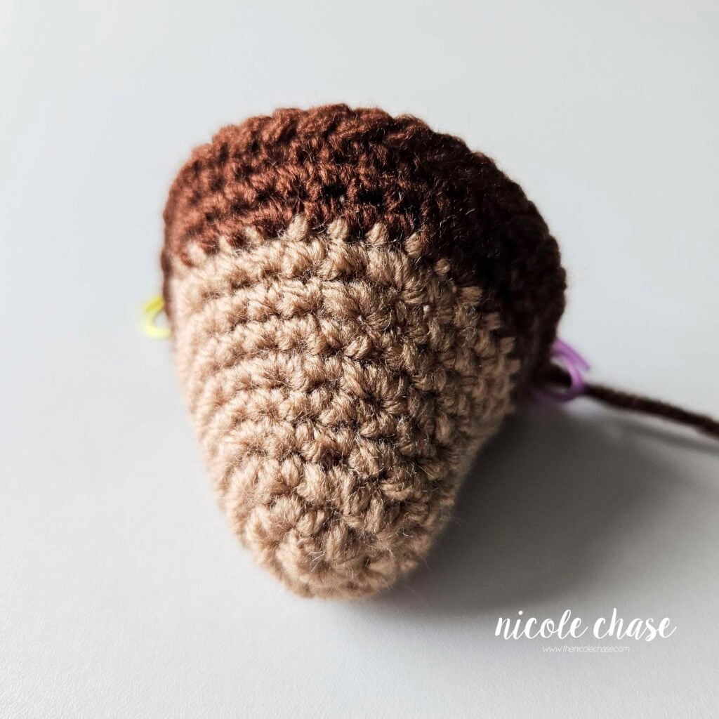 The head of the amigurumi monkey after finishing R12, where you are preparing to place the safety eyes. 