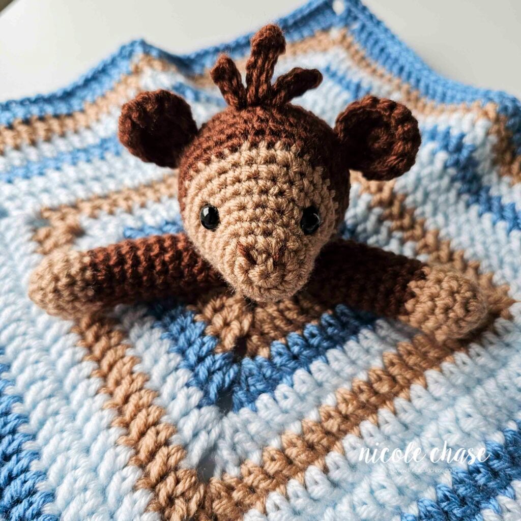 The crochet monkey's arms have been sewn into place on this security blanket crochet pattern. 