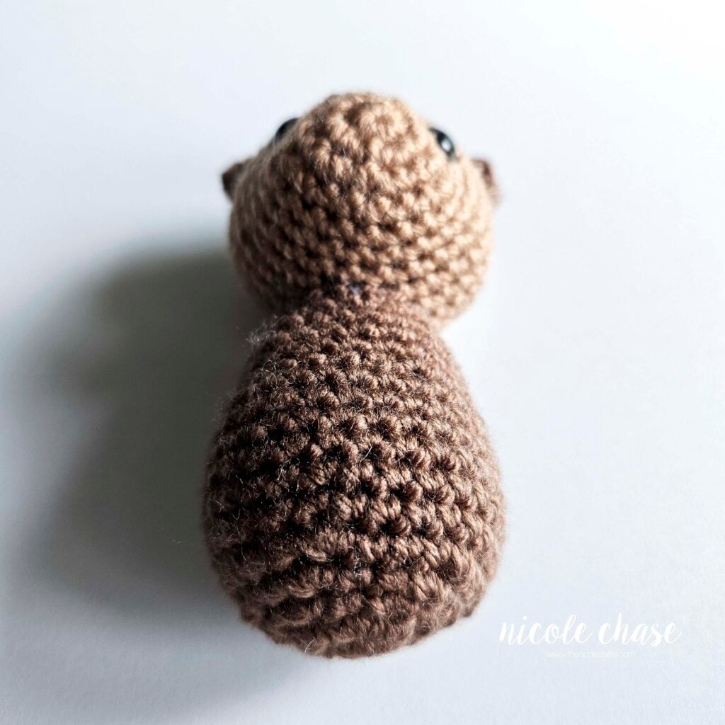 An angled front view of the body and head sewn together for this otter crochet pattern.