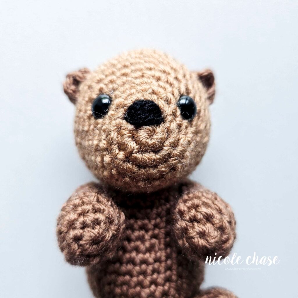 The yarn ends have been weaved in after embroidering the nose of the amigurumi otter.