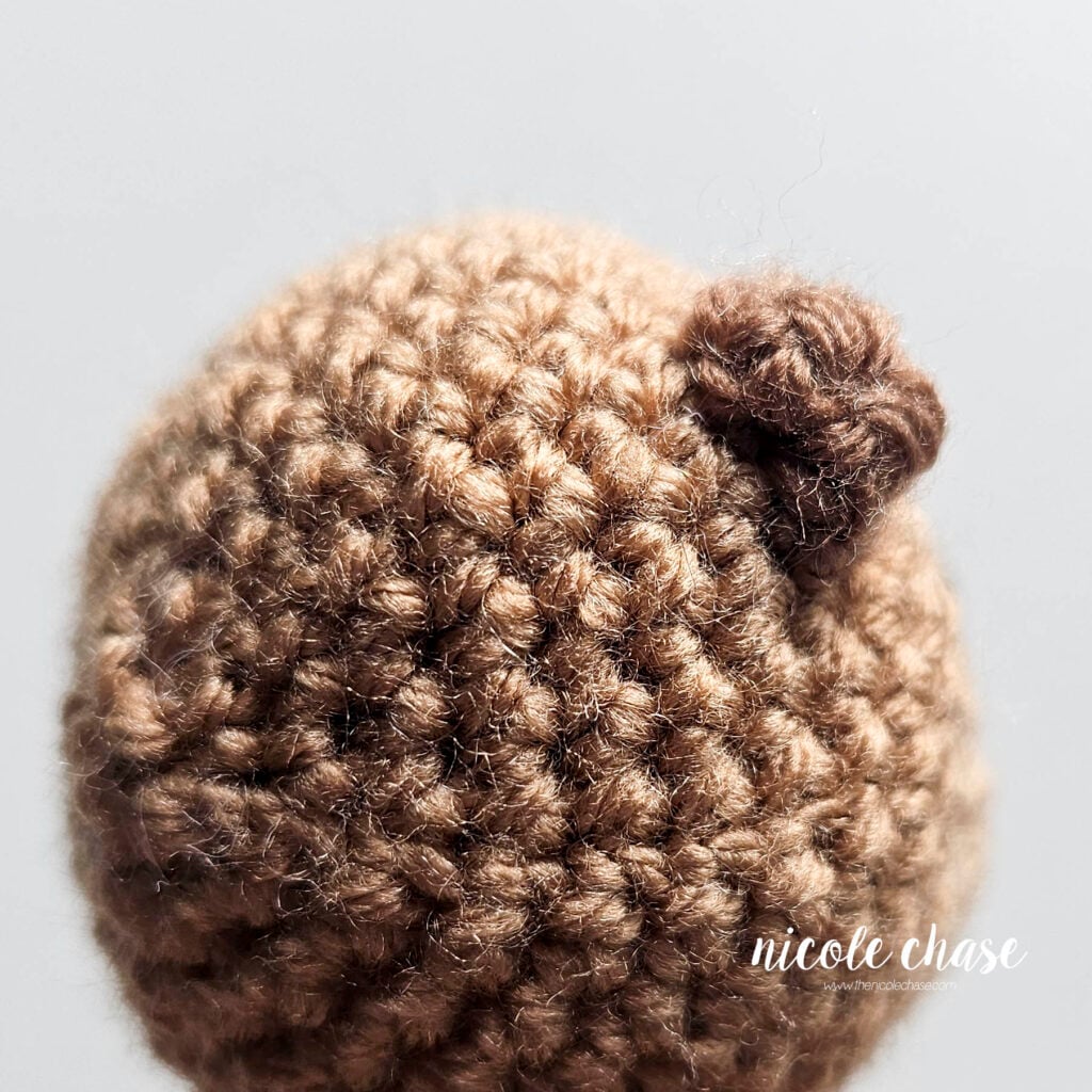 A view of the back of the crochet otter's ear sewn into place on the head.