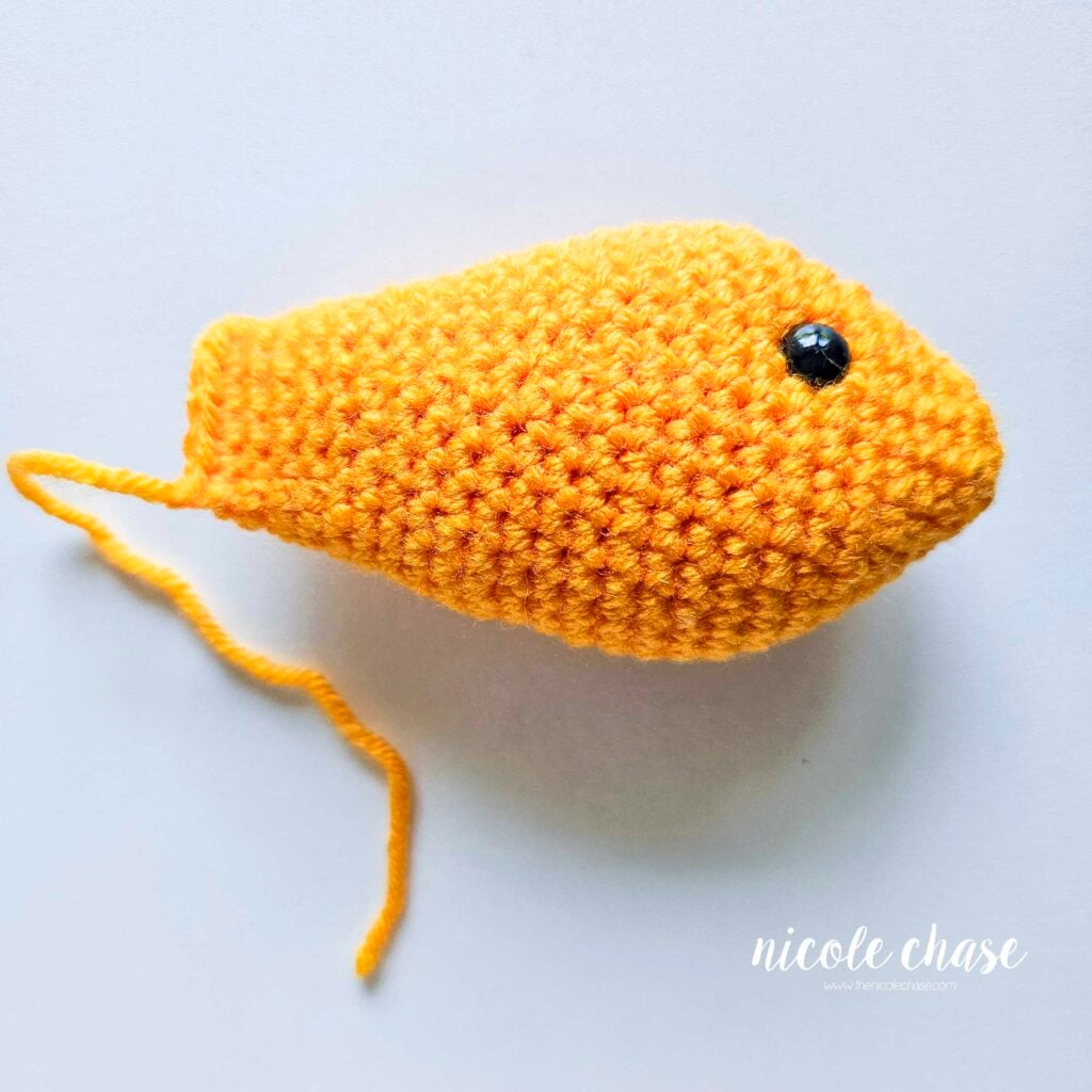 The finished body of the fish crochet pattern has been completed in a bright yellow yarn.