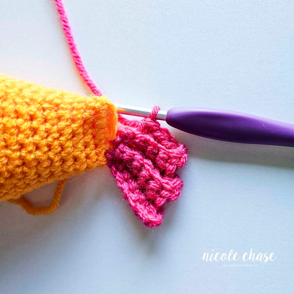 The single crochet stitches of the tail fin of R5 at the end of the fish body before joining it to the base of the fish.