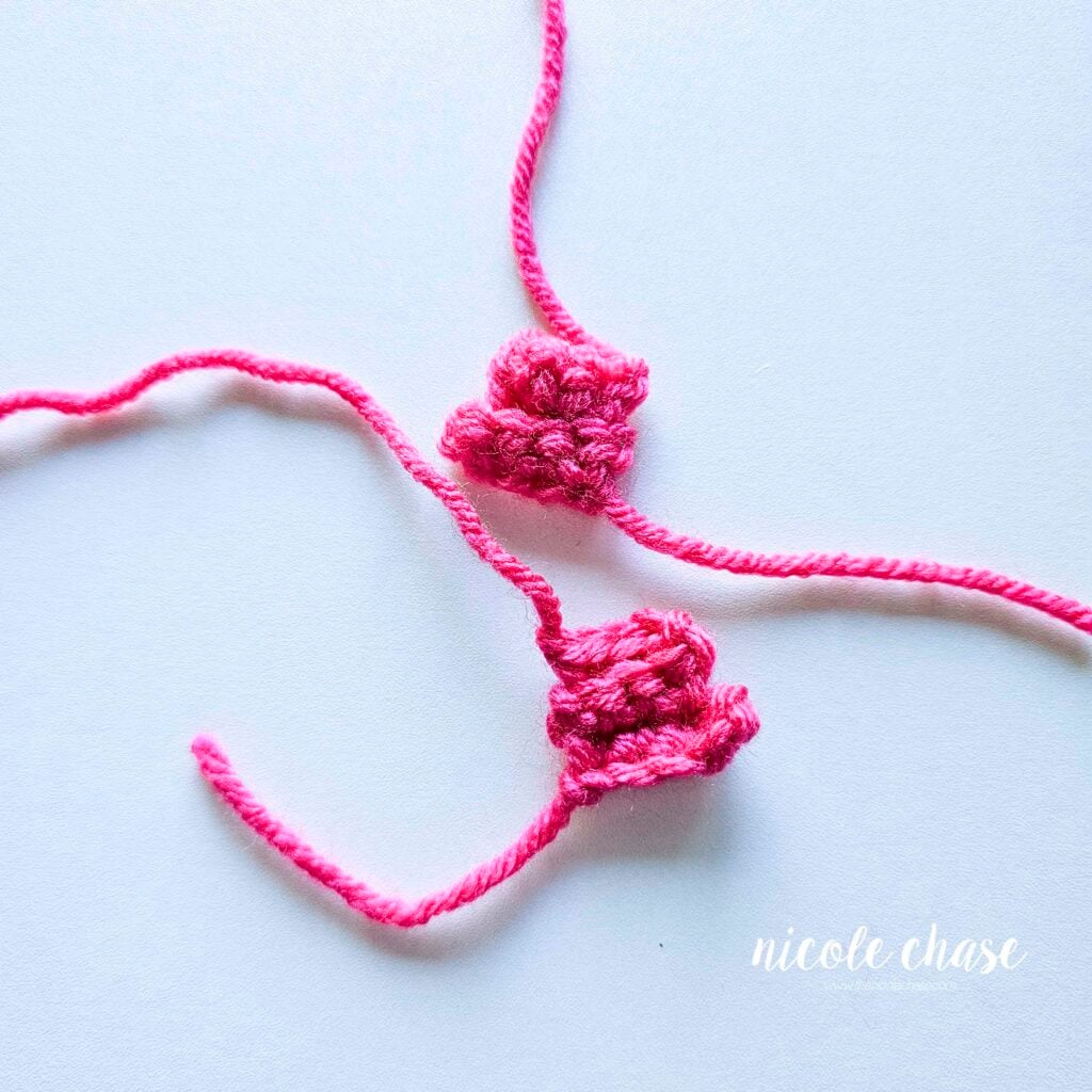 The two completed side fins of the crochet fish are made in pink yarn and are awaiting assembly.