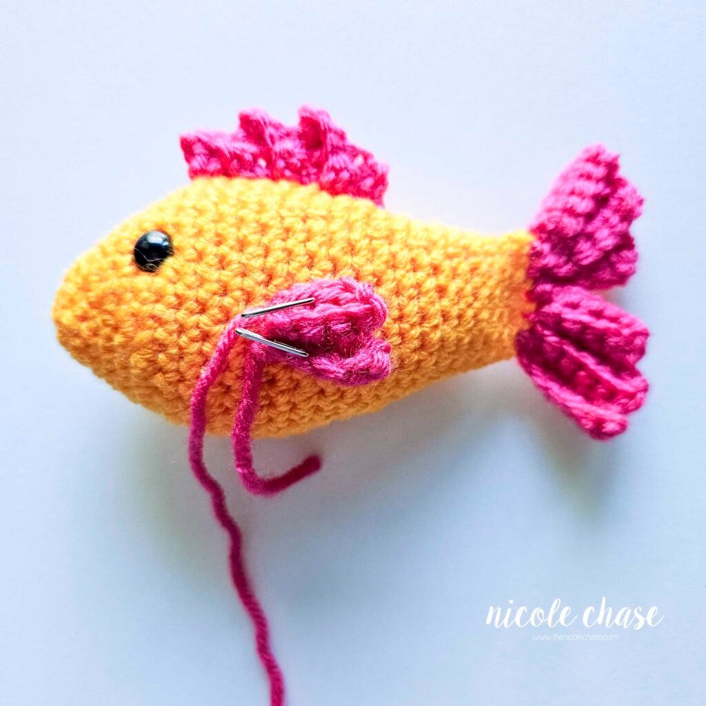 The side fin has been pinned into place on the side of the fish's body and is awaiting sewing.