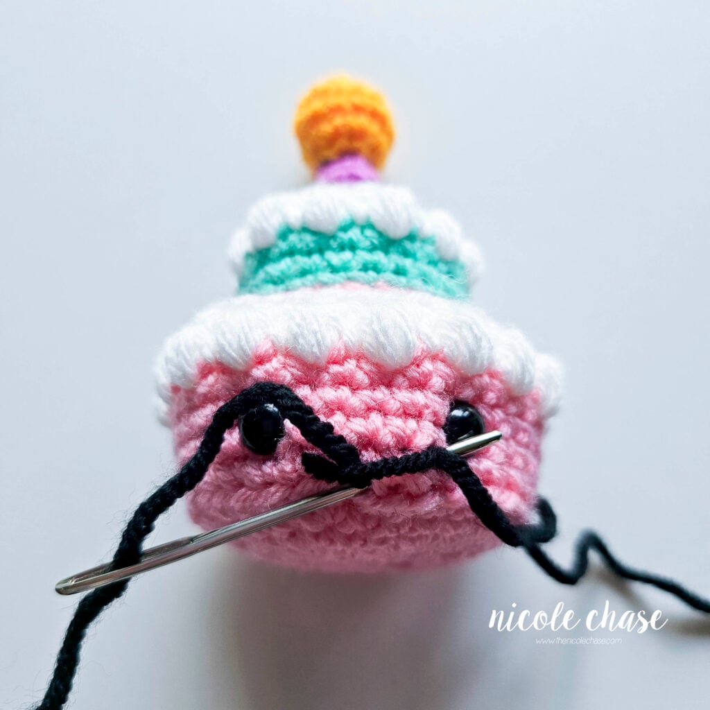 The yarn has been looped over the straight line and the yarn needle is now pushed back out to the starting point of the mouth.