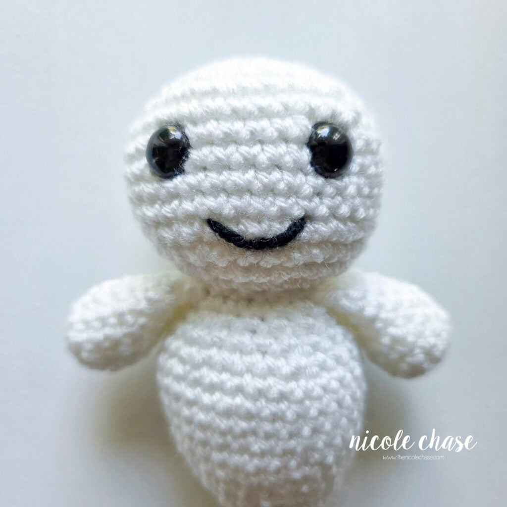The yarn tails from the smile embroidery have been secured and hidden inside, and the smile for the ghost amigurumi is now complete.