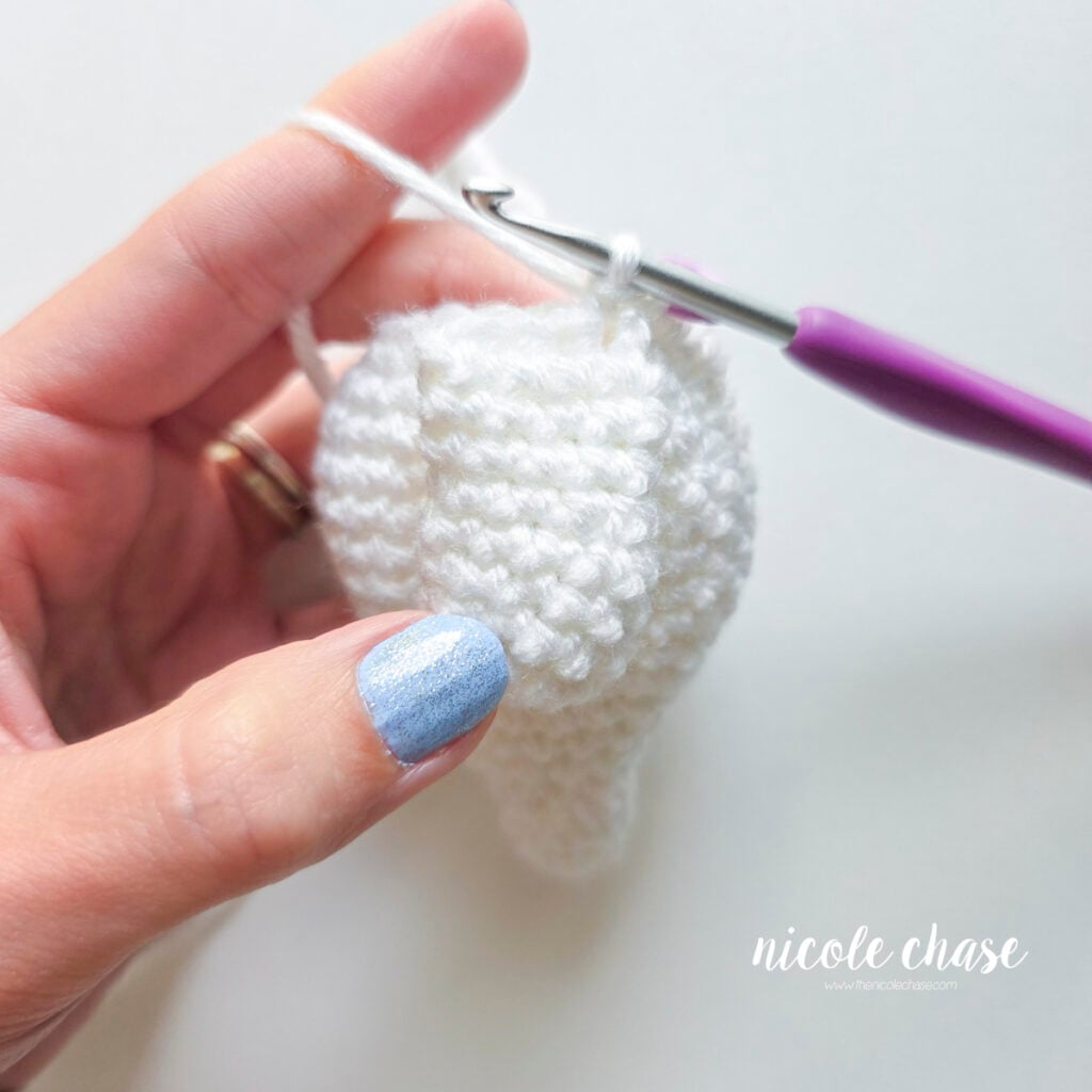 The first single crochet stitch has been completed to join the arm and body together.