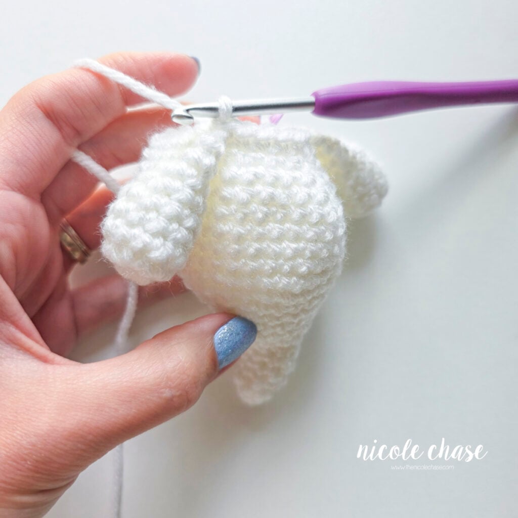 The second arm is now being joined to the body with the first single crochet.