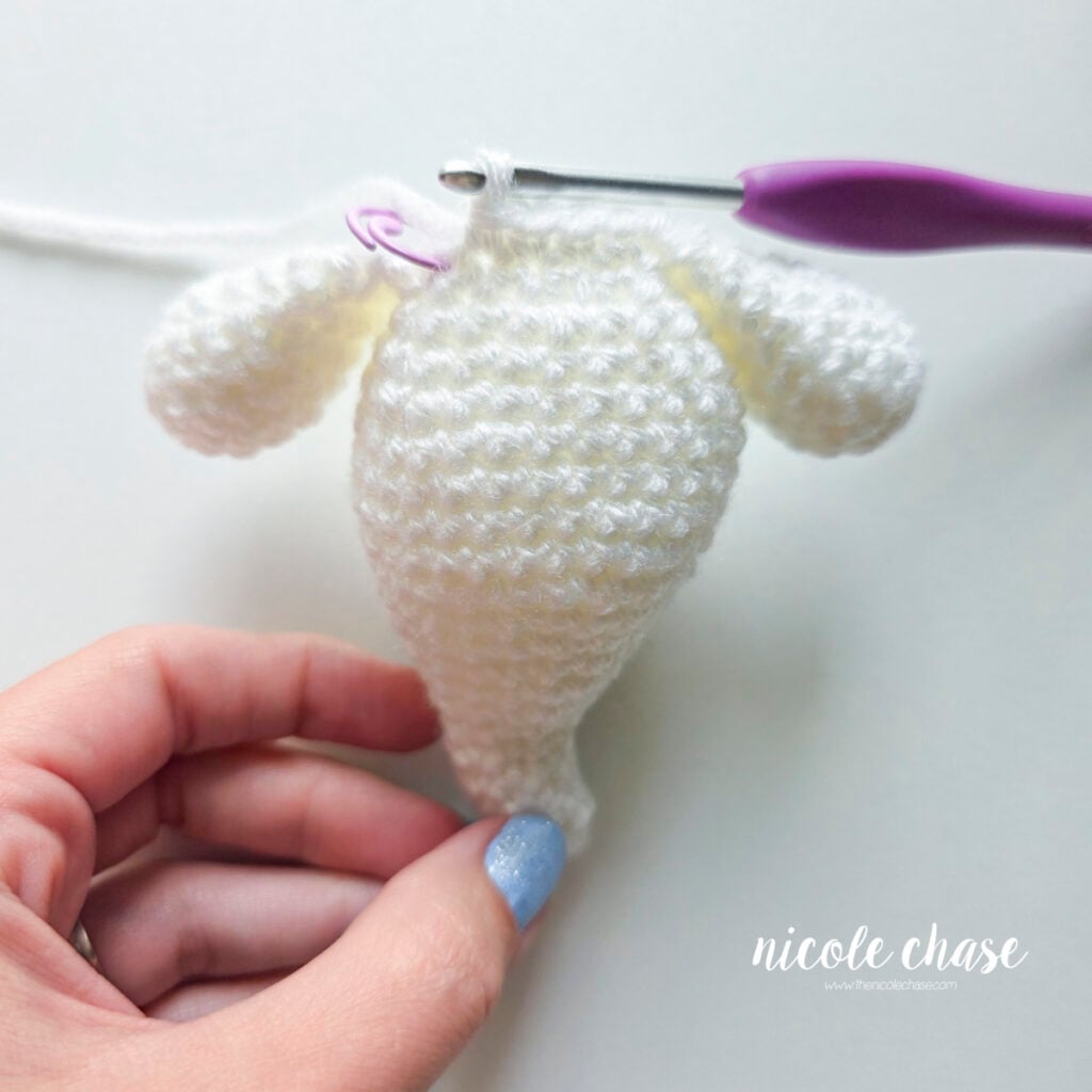 The remaining stitches of this round have been completed and you have now reached the stitch marker. Both arms have been crocheted in place.