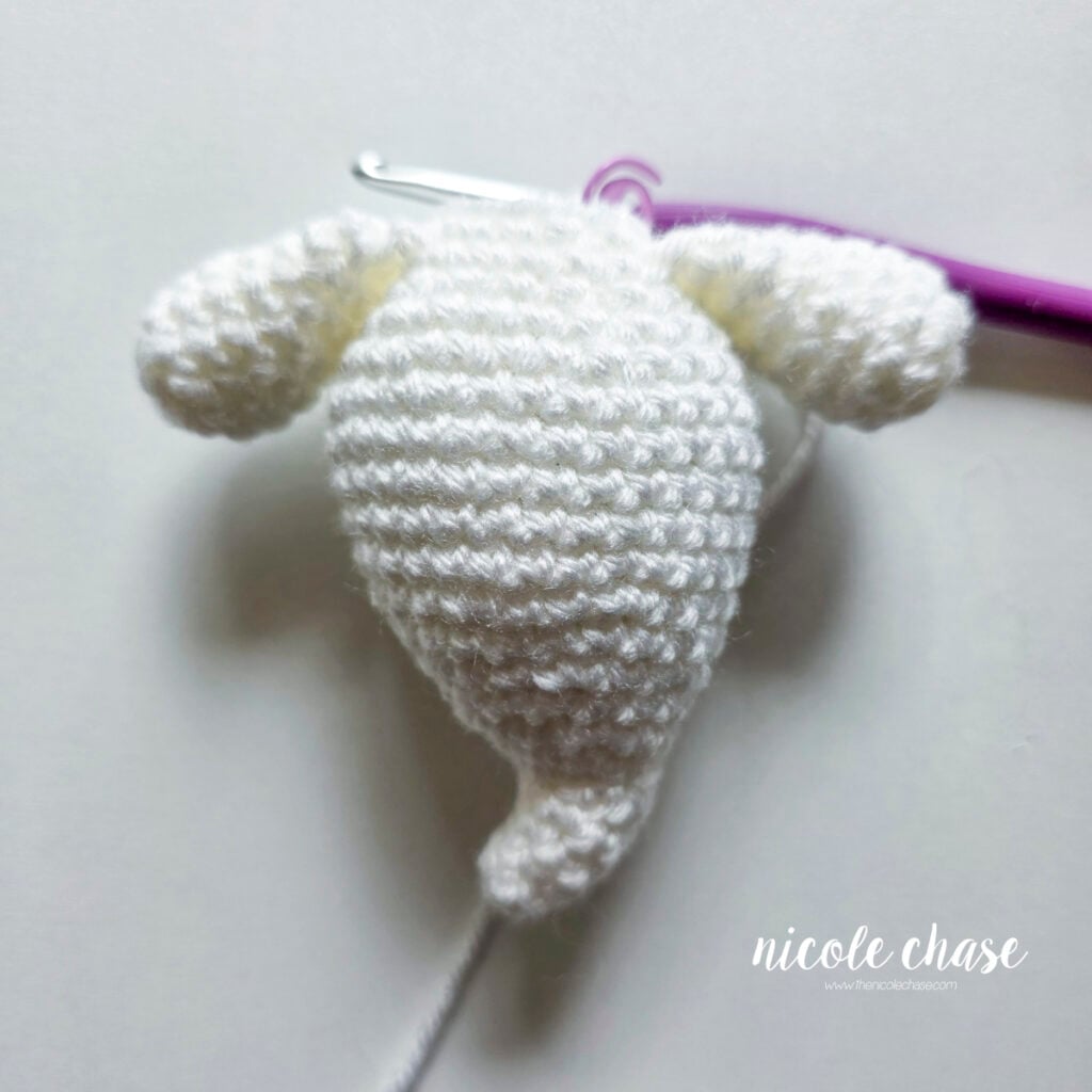 A front view of the arms crocheted in place on the body of the ghost amigurumi.