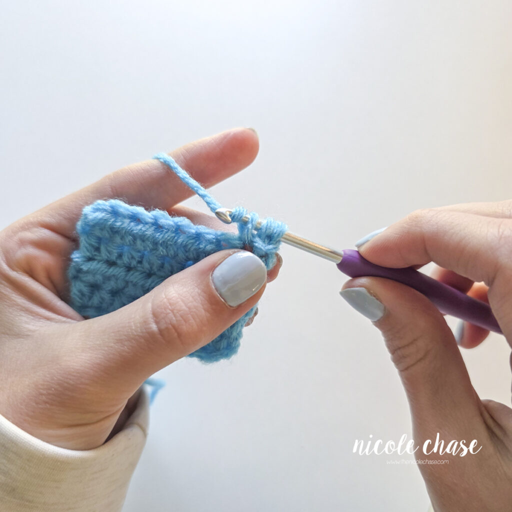 Drawing the working yarn through three loops on the crochet hook. 