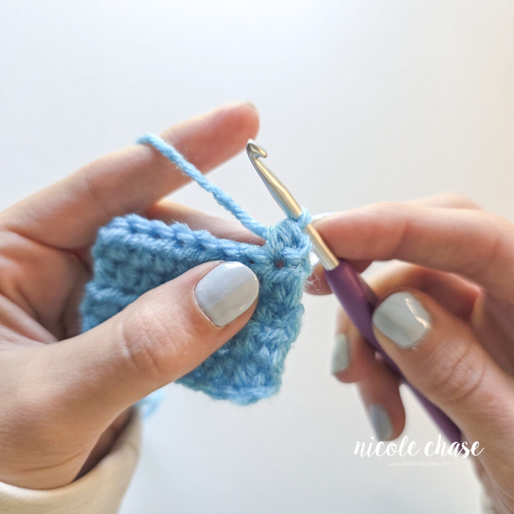 Close-up view of a completed half double crochet stitch on a blue swatch. 
