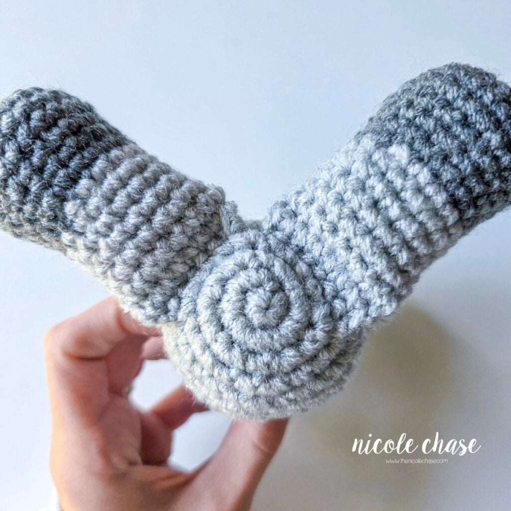 The underside of the crochet raccoon with the legs sewn into place. 